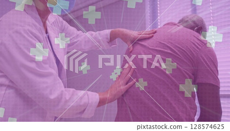 Multiple medical symbol floating against doctor examining back of senior man at hospital 128574625
