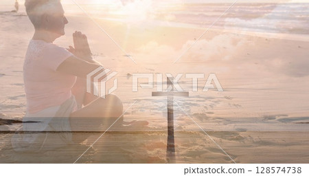 Image of crucifix over senior caucasian praying woman on the beach Image of crucifix over senior caucasian praying woman on the beach 128574738
