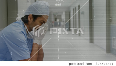 Composite image of tv static effect against stressed male worker at hospital Composite image of tv static effect against stressed male worker at hospital 128574844