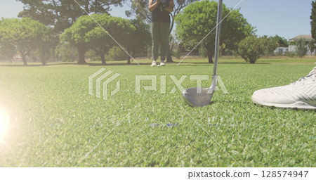 Image of light trails over senior caucasian couple playing golf on golf course 128574947