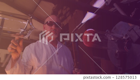 Image of caucasian male worker making glass in workshop 128575013