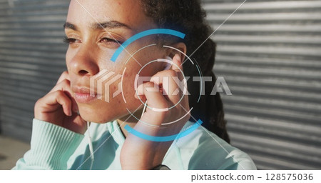 Image of scope scanning over biracial woman wearing earphones 128575036