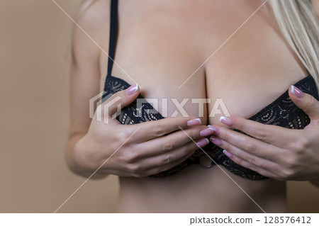 Close-up of sexy breasts in bra. Woman's breasts or big natural boobs in lingerie. Plastic surgery 128576412
