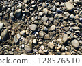 Wet pebbles on the beach. Screen background. 128576510