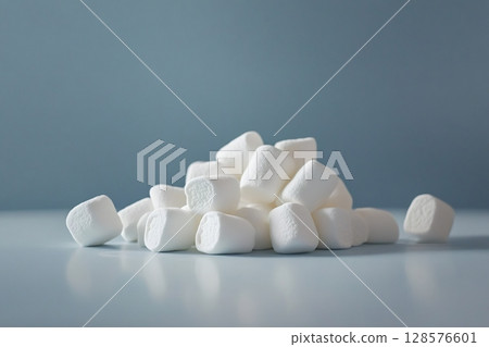 Pile of marshmallows forming a small mountain on a blue background 128576601