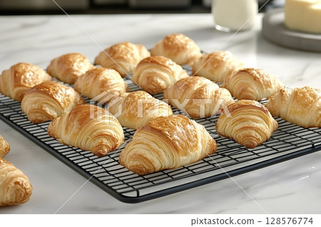 Freshly baked croissants cooling on a wire rack in the kitchen 128576774