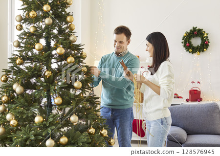 Couple Decorating A Festive Tree Celebrating New Year Or Christmas At Home 128576945