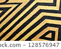 Gold and black stripes. Abstract background with a fragment of a labyrinth. 128576947