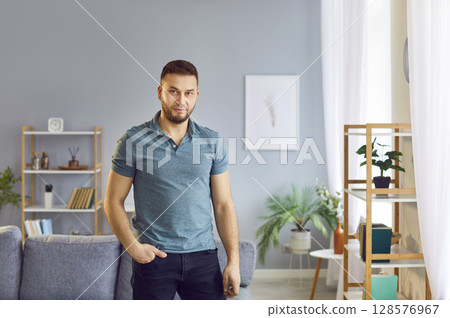 Portrait of an attractive man standing in a confident pose with his hand in his pocket. 128576967