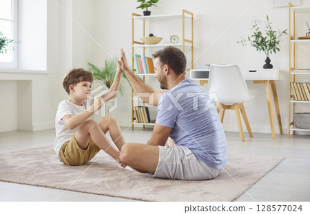 Father And Son Giving High Five During Home Fitness Training Father And Son Giving High Five During Home Fitness Training 128577024
