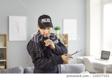 Police Officer Talking On Wireless Radio During Crime Investigation 128577101