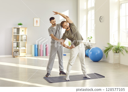Therapist Assisting Patient With Stretching Exercises During Physiotherapy Therapist Assisting Patient With Stretching Exercises During Physiotherapy 128577105