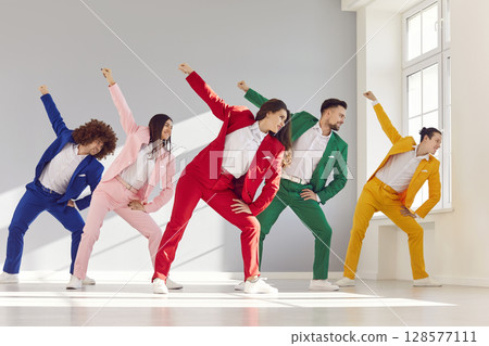 Group of young people dancers wearing bright stylish trendy suits dancing together in modern studio 128577111