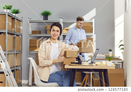 Woman working in logistics center with male colleague preparing order for client in warehouse Woman working in logistics center with male colleague preparing order for client in warehouse 128577185