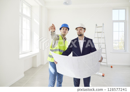 Builder Discussing Construction Plan With Customer At Site 128577241