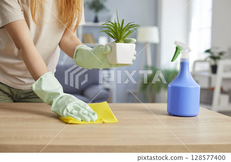 Close-Up Of Woman Dusting And Polishing Furniture During Home Cleaning 128577400