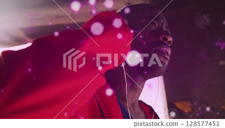 Glowing molecular structures floating against african american male boxer wearing earphones 128577451