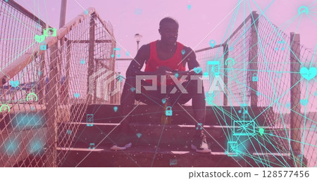 Globes of digital icons against african american fit man using smartwatch sitting on the stairs Globes of digital icons against african american fit man using smartwatch sitting on the stairs 128577456