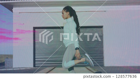 Image of pink trails over biracial woman stretching outdoors Image of pink trails over biracial woman stretching outdoors 128577636