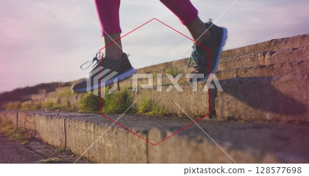 Red hexagonal shape against low section of a woman running down the stairs 128577698