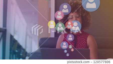 Image of media icons over biracial businesswoman with coffee using laptop Image of media icons over biracial businesswoman with coffee using laptop 128577806