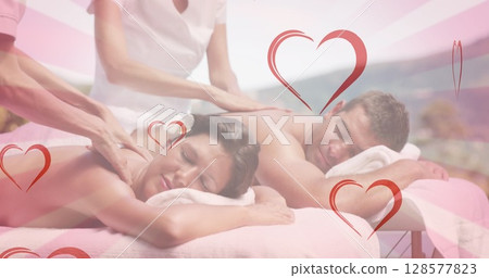 Image of hearts falling over caucasian couple in spa during massage 128577823