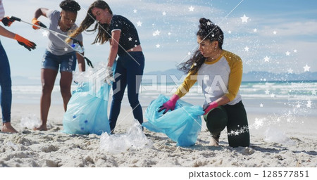 Image of stars over diverse female and male volunteers picking up rubbish on beach Image of stars over diverse female and male volunteers picking up rubbish on beach 128577851