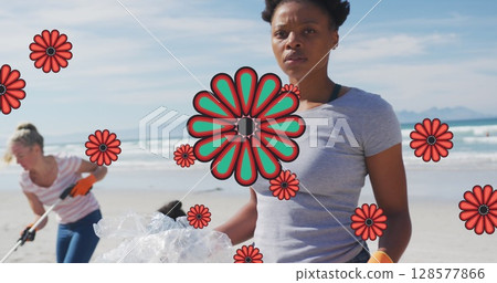 Image of flowers over african american female volunteer picking up rubbish on beach 128577866