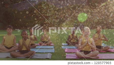 Image of light spots over diverse children practicing yoga and meditating Image of light spots over diverse children practicing yoga and meditating 128577903
