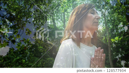 Image of trees over senior caucasian woman practicing yoga and meditating 128577934