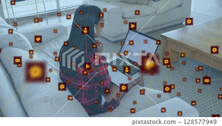 Image of network of connections with icons over biracial woman using laptop with copy space Image of network of connections with icons over biracial woman using laptop with copy space 128577949