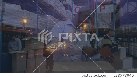 Image of road at night over diverse workers in warehouse 128578040