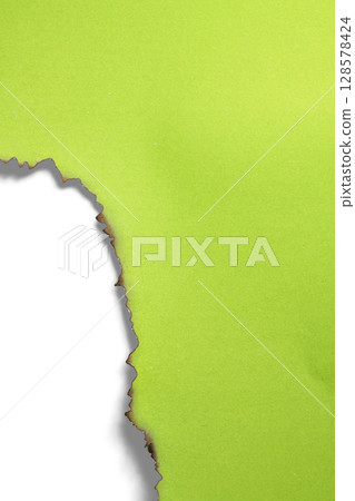 Green paper ripped message torn with burnt edges isolated on a white background. Copy space 128578424