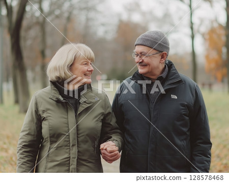 Couple Enjoys a Leisurely Walk in the Park During Early Autumn Season Couple Enjoys a Leisurely Walk in the Park During Early Autumn Season 128578468
