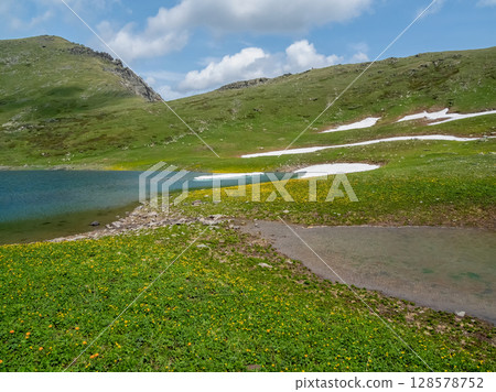 Small mountain lake in sunny green valley. 128578752