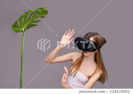 Young caucasian female engaging with virtual reality while interacting Young caucasian female engaging with virtual reality while interacting 128578801