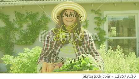 Image of organic vegan text in green letters over caucasian woman holding tray with vegetables 128579130
