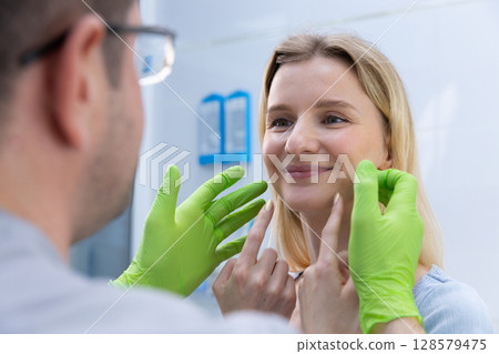 Patient Consultation: Examining Facial Features with Professional Guidance for Cosmetic Treatments and Enhancements in a Modern Medical Environment Patient Consultation: Examining Facial Features with Professional Guidance for Cosmetic Treatments and Enhancements in a Modern Medical Environment 128579475