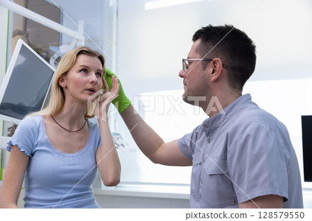 A Healthcare Provider During a Consultation with a Patient in a Modern Medical Office Setting, Displaying Compassionate Care and Professionalism in Facial Treatment 128579550