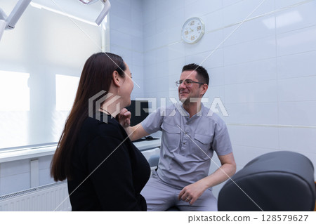 Professional Dental Consultation: A Friendly Patient-Doctor Interaction in a Modern Clinic Setting with Bright Interiors for Comprehensive Oral Health Care Professional Dental Consultation: A Friendly Patient-Doctor Interaction in a Modern Clinic Setting with Bright Interiors for Comprehensive Oral Health Care 128579627