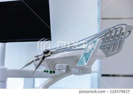 Modern Dental Equipment with a Focus on Precision Tools and a Sleek Monitor Displaying White Space for Patient Comfort in a Clean Office Environment Modern Dental Equipment with a Focus on Precision Tools and a Sleek Monitor Displaying White Space for Patient Comfort in a Clean Office Environment 128579637