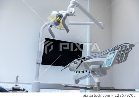 Modern Dental Chair Setup in a Bright Treatment Room Featuring Advanced Technology for Patient Care and Comfort During Dental Procedures 128579703