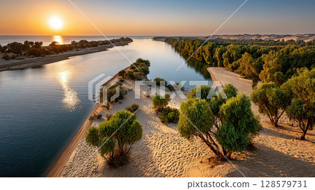 Idyllic sunset over serene river and lush forest in sandy desert landscape 128579731