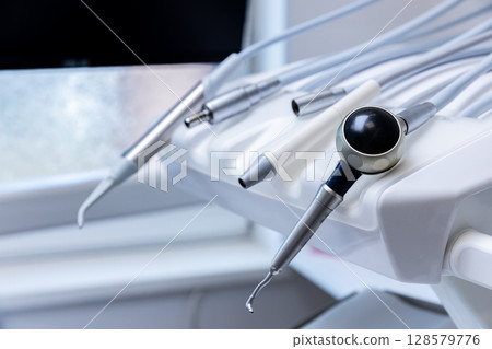 Various Dental Instruments and Tools Displayed on a Chair in a Modern Dental Clinic Setting, Showcasing Their Design and Functionality 128579776