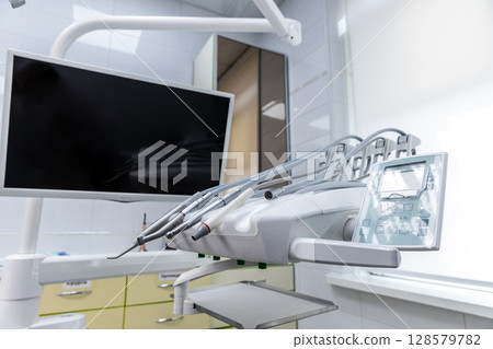 Modern Dental Clinic Equipment Featuring an Advanced Dental Chair and Monitor for Enhanced Patient Experience and Efficient Dental Procedures in a Sleek Environment Modern Dental Clinic Equipment Featuring an Advanced Dental Chair and Monitor for Enhanced Patient Experience and Efficient Dental Procedures in a Sleek Environment 128579782