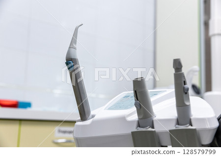 Advanced Dental Equipment in a Modern Clinic Setting, Featuring a Close-Up of an Innovative Dental Handpiece for Professional Oral Care Procedures 128579799