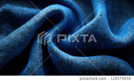 Close-up of blue textured fabric with intricate weave pattern and soft folds creating elegant waves and shadows Close-up of blue textured fabric with intricate weave pattern and soft folds creating elegant waves and shadows 128579838