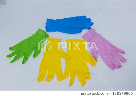 A Vibrant Collection of Colorful Rubber Gloves Arranged Neatly on a White Surface, Showcasing a Mix of Colors for Various Cleaning and Protective Uses A Vibrant Collection of Colorful Rubber Gloves Arranged Neatly on a White Surface, Showcasing a Mix of Colors for Various Cleaning and Protective Uses 128579906