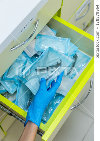 Organized Dental Tools Awaiting Use: A Pharmacist's Precision in the Preparation of Sterilized Instruments, Showcase of Hygiene and Care in Medical Settings Organized Dental Tools Awaiting Use: A Pharmacist's Precision in the Preparation of Sterilized Instruments, Showcase of Hygiene and Care in Medical Settings 128579964