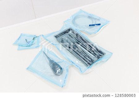 An Array of Surgical Instruments Packaged in Sterile Blue Wrappings for Medical Use in Healthcare Facilities and Hospital Settings, Ensuring Patient Safety and Hygiene An Array of Surgical Instruments Packaged in Sterile Blue Wrappings for Medical Use in Healthcare Facilities and Hospital Settings, Ensuring Patient Safety and Hygiene 128580003
